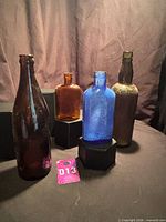 Group shot of four vintage bottles showing colors and shapes
