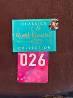 Charm attached to Walt Disney Classics Collection backing card