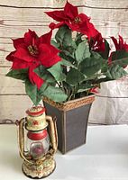 Full view of poinsettia in planter with lantern