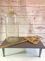 Entire lot showing glass carboy on wooden stand with rattan beater