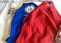 Three aprons laid out showing colours and logos