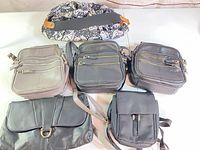 All six bags laid out: four black, two gray/taupe, patterned bag visible