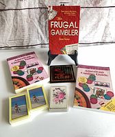 All items group shot displaying books standing and laid flat, coaster and card decks