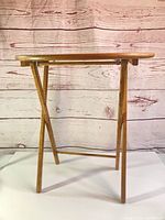 Full view of folded wooden TV tray table standing
