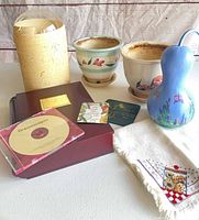 Group shot of all items: both pots, gourd, vase, wooden box, CD, towel