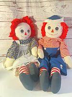 Raggedy Ann and Raggedy Andy dolls seated side by side