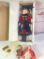 Boxed porcelain doll with two small dolls and certificate