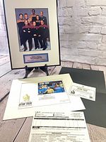 Overall lot showing framed Voyager photo on easel, matted stamp cache, COA and paperwork