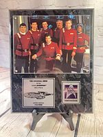 Full framed plaque on easel showing photo, plates, frame