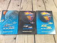 Front view of three boxed card sets in slipcases