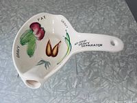 Top view showing interior vegetable motifs, spout and printed text