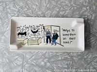 Top view showing full cartoon design and caption on ashtray surface