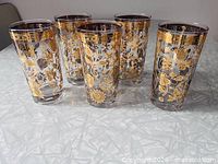 Front view of all five Culver Chantilly glasses showing gold overlay design