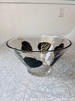 Side view of clear glass bowl showing black and gold leaf pattern