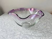 Side view of clear glass bowl with purple-tinted ruffled rim