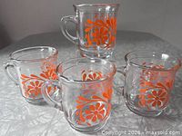 Four clear glass mugs showing full Orange Joe floral pattern