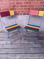 Pair of Kris Folding chairs, full frontal view showing multicolour slats and blue frames