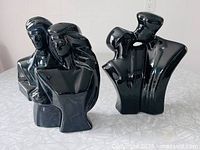 Front view of both black ceramic couple sculptures