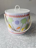 Cylindrical ice bucket front view showing graphics and handle