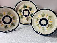 Three Crest-Stone Malma plates displayed upright showing pattern