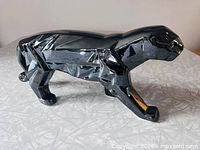 Left side view of glossy black faceted ceramic panther