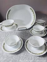Full set of five cup-and-saucer pairs with oval platter