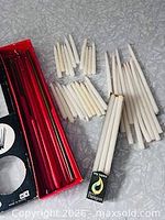 Open red sleeve holding red and green tapers with loose white tapers beside