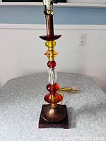 Full view of lamp showing stacked lucite beads and wood base