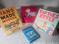 Group shot of three books and one DVD on stands