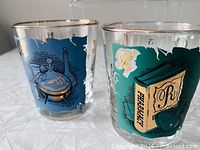 Two glasses close-up showing blue and green panel designs and metallic rims