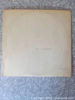 Front of White Album gatefold sleeve showing embossed title and stamped serial number
