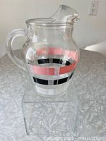 Side view of clear glass pitcher showing full shape and striped pattern