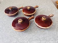 All four Hull Brown Drip casserole crocks with lids displayed top view