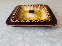 top angled view showing square ashtray, brown glaze, yellow crackle center