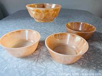 Group shot of four Peach Lustre bowls: three smooth, one Kimberly Diamond
