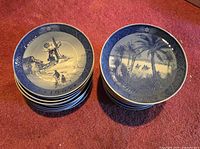Two stacks of Royal Copenhagen plates, top showing 1965 windmill scene and 1972 Bethlehem scene