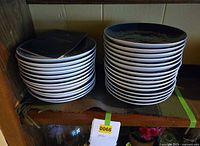 Stacked Royal Copenhagen blue Christmas plates on shelf