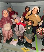 Group of seven Byers Choice caroler figurines on shelf