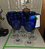 Eight cobalt blue crystal goblets grouped on counter