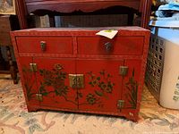Front view of cabinet showing drawers, doors, painted motifs