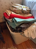 Bin with stacked linens beside bed