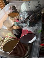 Bin containing multiple small decorative lamp shades, assorted colors and patterns