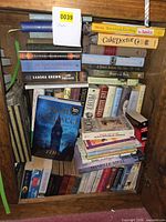 Bookcase shelf showing variety of stacked books