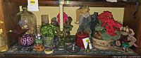 Overall shelf contents showing candlesticks, cloche, faux flowers, ginger jar and other decor