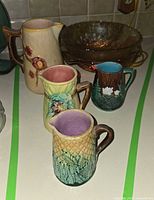 Group shot showing all four pitchers and carnival glass bowl