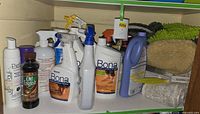 Shelf with multiple cleaning bottles and cloths