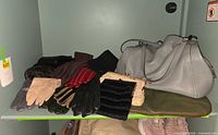 Overview of gloves, clutches and Coach handbag on shelf