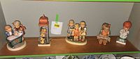 All six Hummel figurines displayed on shelf