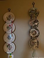 Two vertical wall racks with Johnson Brothers floral plates and scenic transferware plates