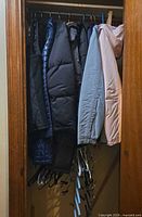 Closet view showing multiple coats and hangers